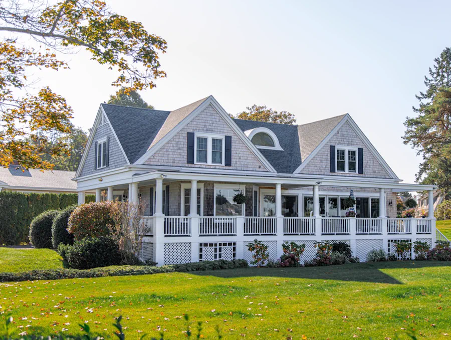 Shingled house with a wraparound porch on a wide lawn