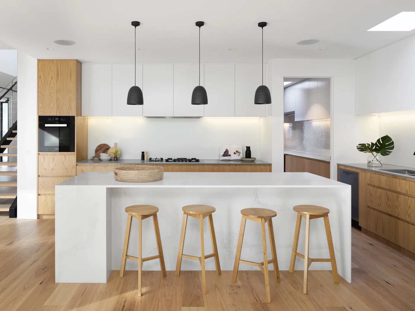 Kitchen island with four stools under three pendant lights