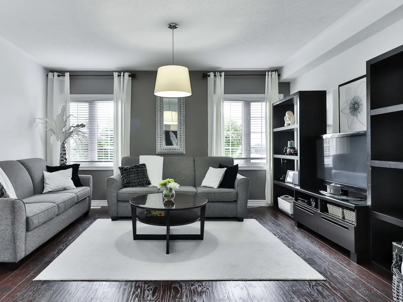 Living room with a bay window and a wall-mounted television