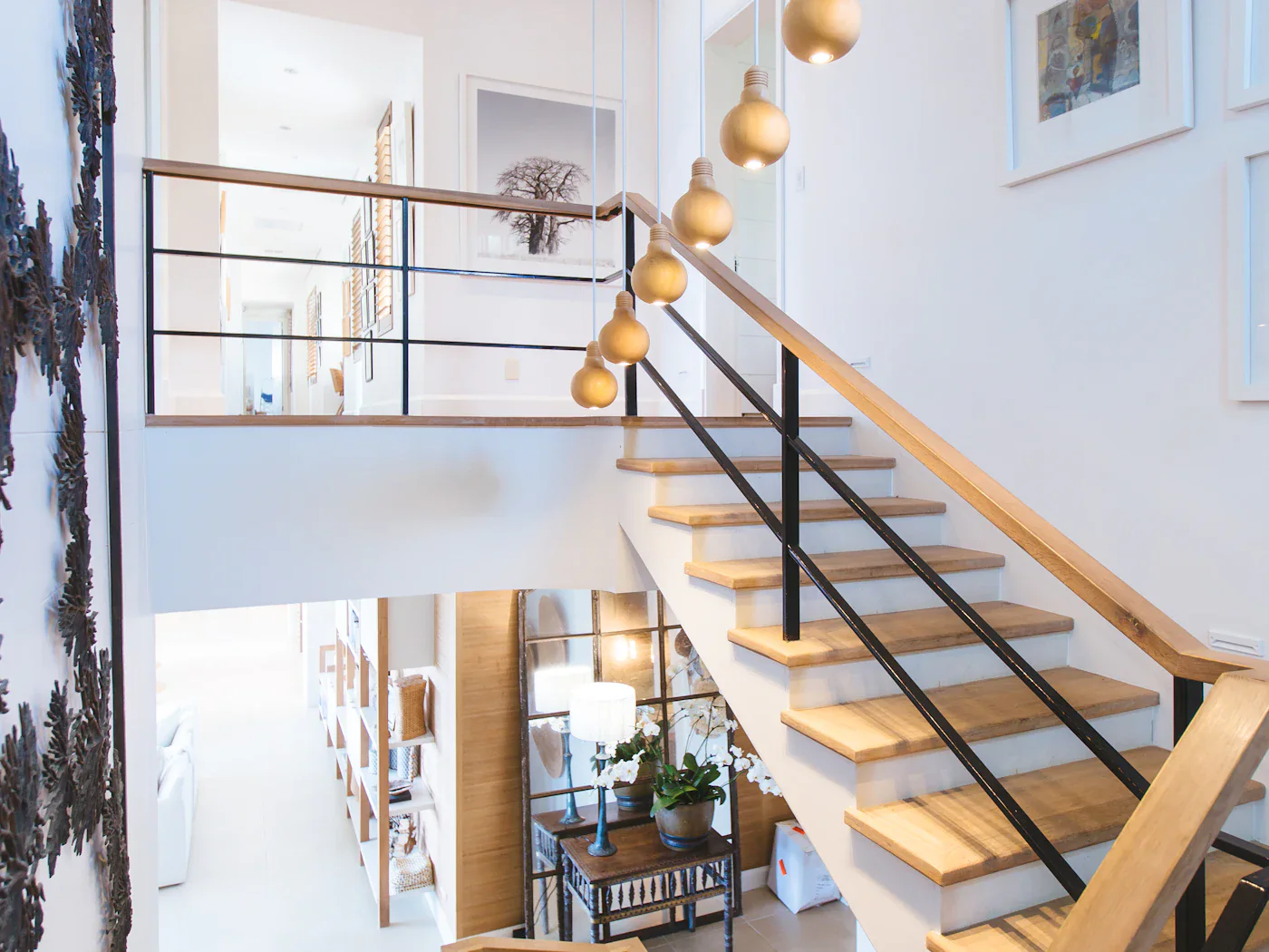 The open staircase seen from the landing, with a hanging light