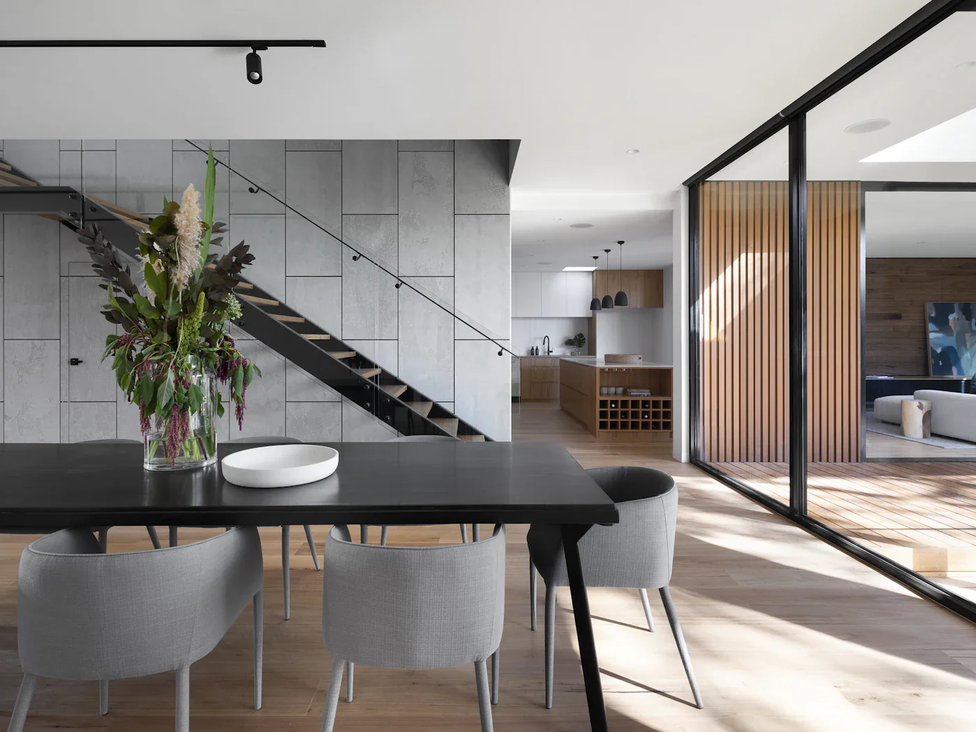 Dining table for six against a glass wall onto the courtyard