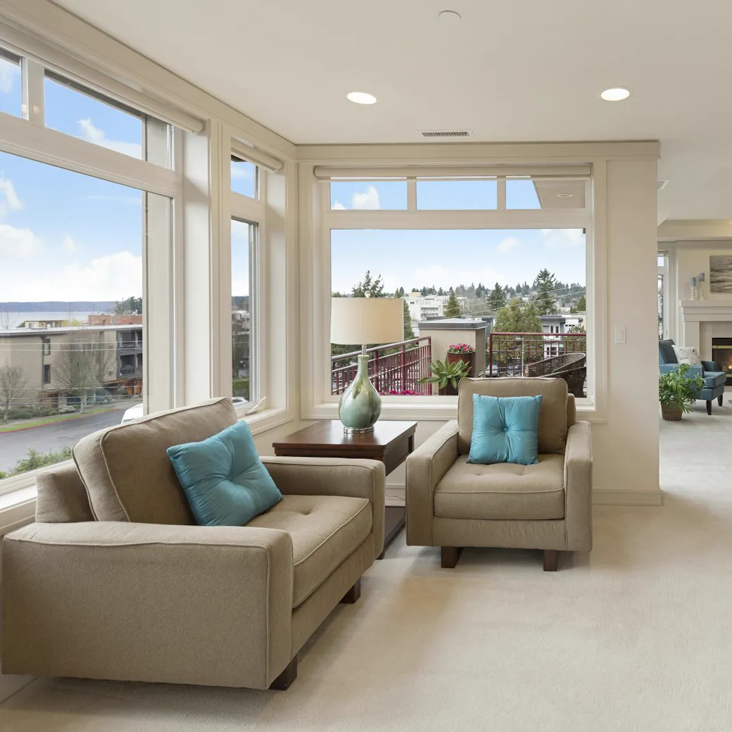 Bright living room with tall windows onto the street