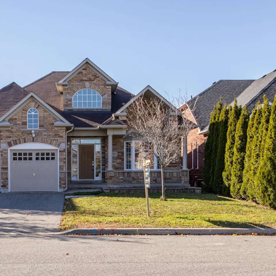 Suburban house with a wide driveway and autumn trees